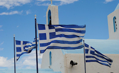 Greece has many gorgeous churches and flags.