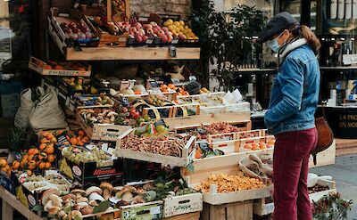 Lady browsing fresh produce in Parma, Italy. Unsplash@Gabriella Clare Marino