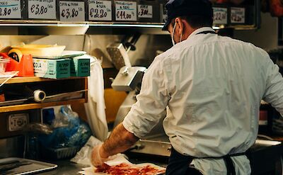 Man preparing Palma ham, Palma, Italy. Unsplash@Gabriella Clare Marino