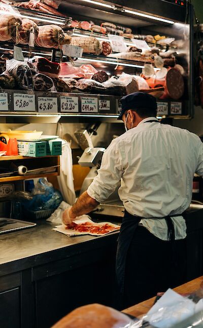 Man preparing Palma ham, Palma, Italy. Unsplash@Gabriella Clare Marino