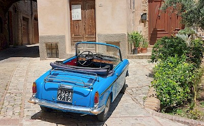 Blue car parked in Spello, Umbria walking tour, Italy. Unsplash@Csilla Monica Slezsak