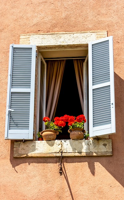 Red flowers on a windowsill in Assisi, Italy. Unsplash@Fernando Tavora