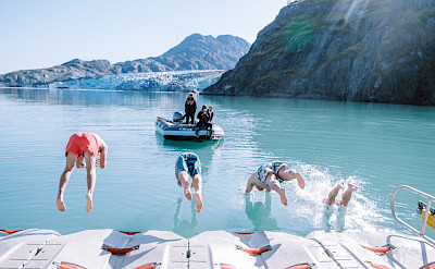 Guests taking a polar plunge of the kayak launch pad in Alaska. ©TO
