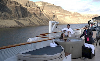 Guests having wine in the hot tub aboard The Legacy. ©TO